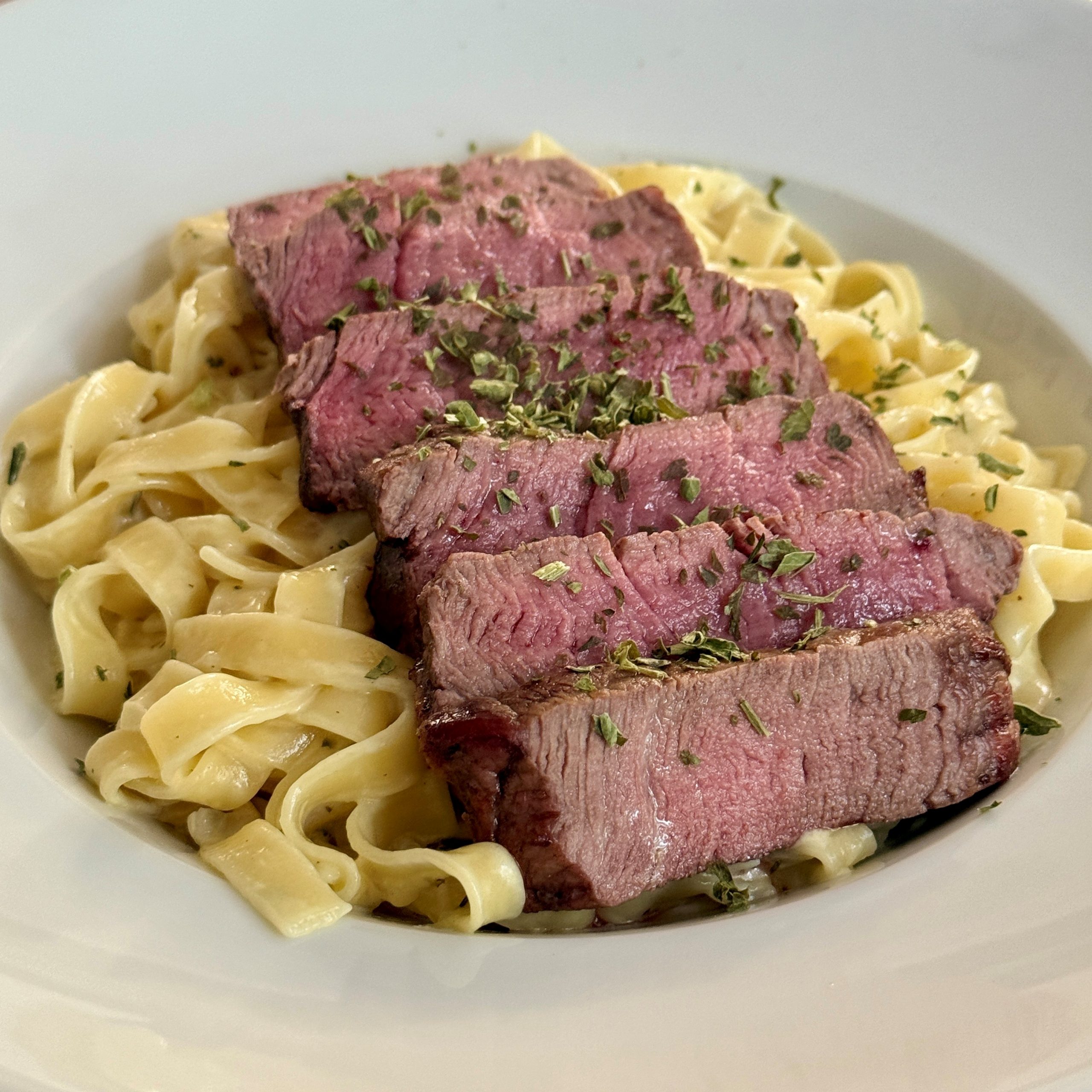 Tagliatelle mit cremiger Parmesan-Sauce und Steakstreifen